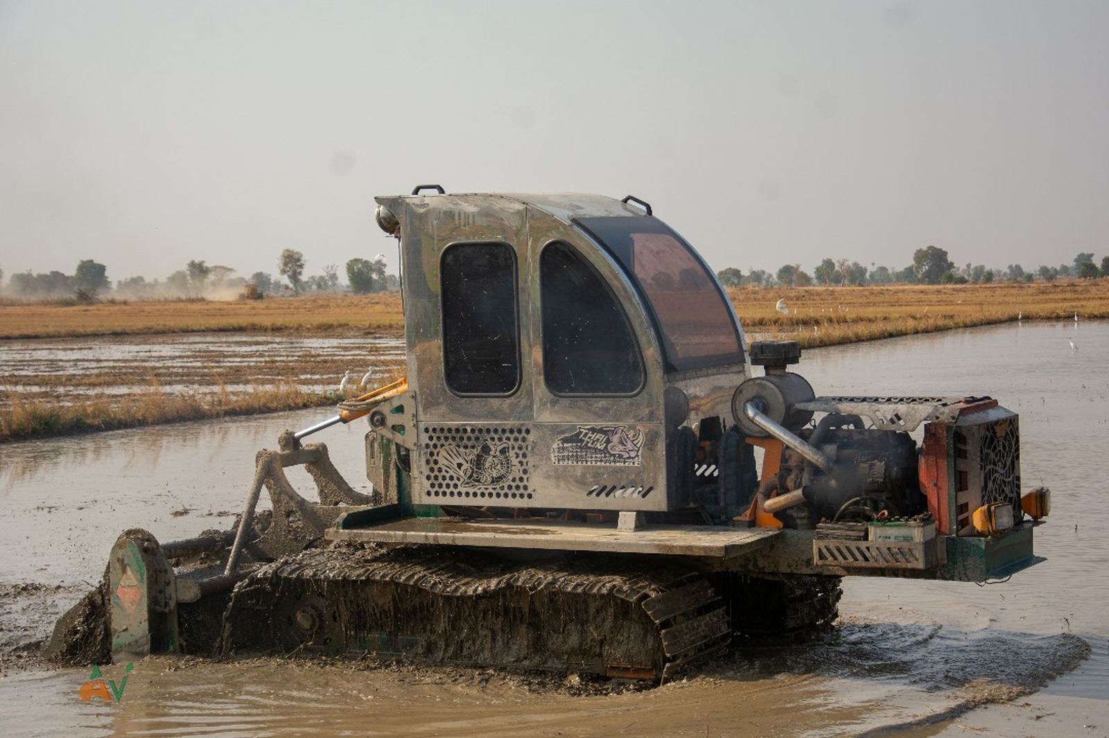 Crawler tractor working a flooded rice field